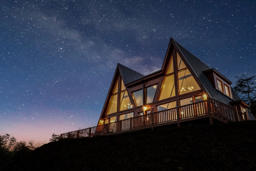 Two A-frame cabins side by side under a night sky